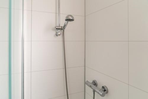 a shower with a shower head in a bathroom at Appartement Senang, Resort Amelander Kaap in Hollum
