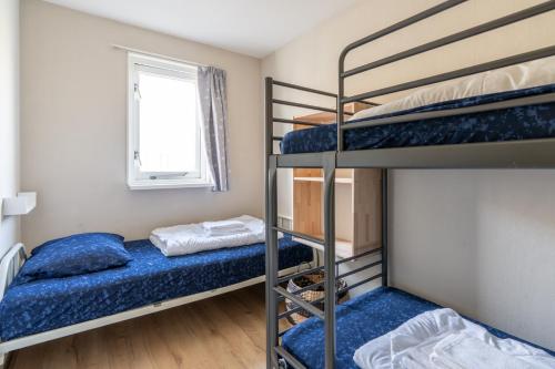a bedroom with two bunk beds and a window at Appartement Senang, Resort Amelander Kaap in Hollum