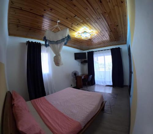 a bedroom with a bed and a wooden ceiling at Akany Tsitoha in Tanjombato