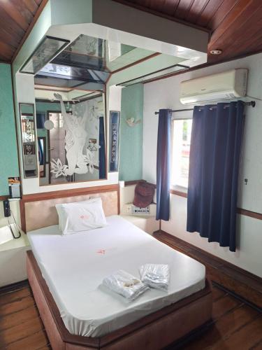 a bedroom with a bed with a large mirror at Hotel Flor da Vila Mariana in São Paulo
