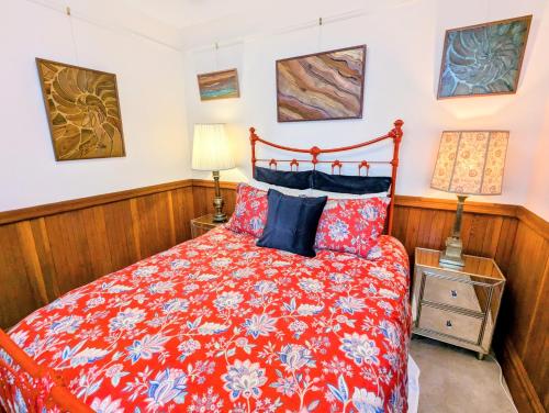 a bedroom with a bed with a red comforter at Perfect Location - 4BD,1BA - Restored Redwood Home in San Francisco
