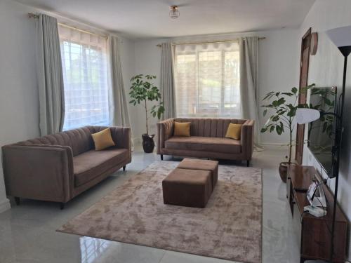 a living room with two couches and a rug at Prime Elgon View 5BR Family Home Private Secure in Eldoret