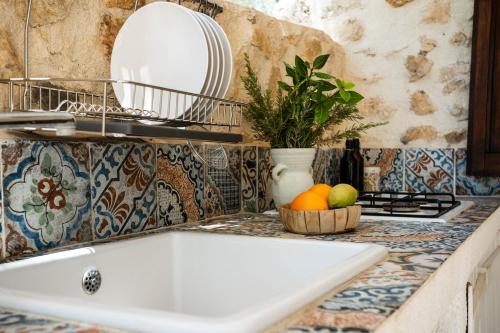 a kitchen counter with a sink and a bowl of fruit at Villa Roba degli Ulivi in Agrigento