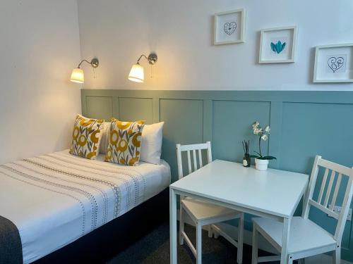 a bedroom with a bed and a desk and a table at Trinity House London Walthamstow in London