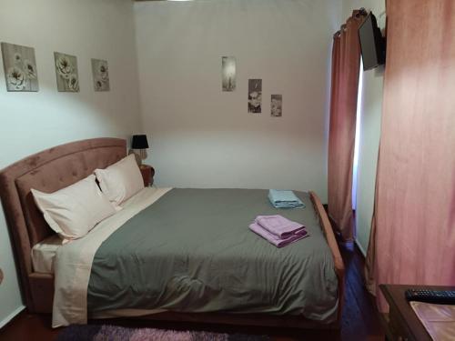 a bedroom with a bed with a green comforter at Aπανεμα Ανδ συγγρου 34 in Galaxidi
