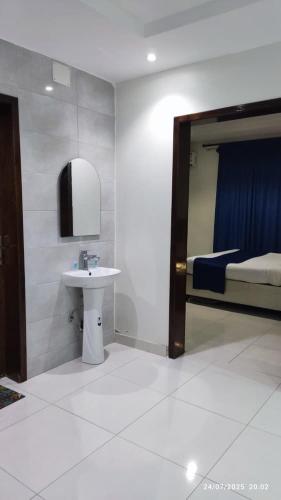 a bathroom with a sink and a mirror and a bed at المبيت 2 جديد in Abha