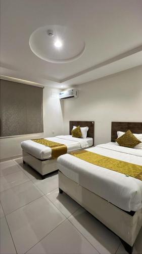 two beds in a hotel room with two bedsvisor at المبيت 2 جديد in Abha