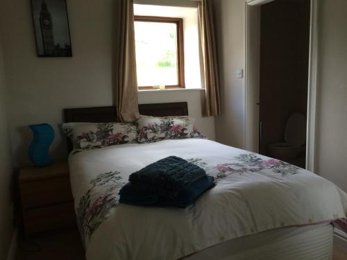 - un lit dans une chambre avec fenêtre dans l'établissement Gibraltar Farm Cottage, à Hebden Bridge