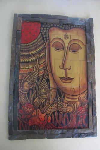 a painting of a face on a wall at Golden Lotus Place in Luang Prabang