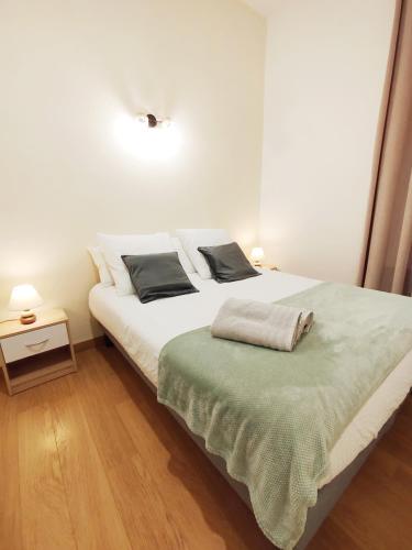 a white bed with two pillows on it in a room at Les Gîtes d'Altaïr - La Petite Ourse in Tarascon-sur-Ariège