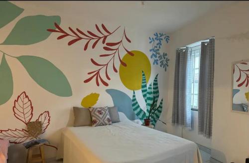 a bedroom with a bed with a floral mural on the wall at São Francisco Aparts in Salvador