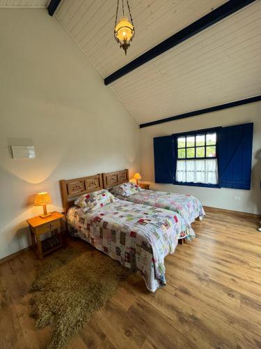 a bedroom with a bed and a window at Quinta dos Faisões in Santo Antônio do Pinhal