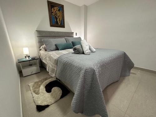 a bedroom with a bed with a gray blanket at 202 Apartaestudio Edificio Natura 54, cercano Centro Comerciales in Ibagué