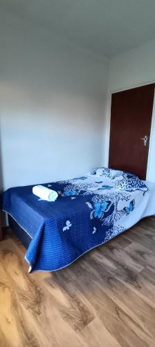 a bedroom with a bed with a blue comforter at Accomodation in Cape Town in Goodwood