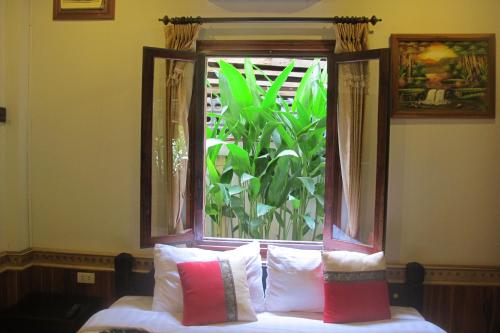 a window with pillows on a bed in a room at Golden Lotus Place in Luang Prabang