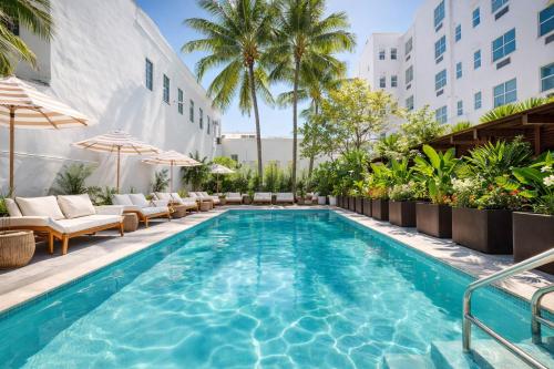 a pool at a hotel with chairs and umbrellas at Global Luxury Suites at The Apex Miami in Miami Beach