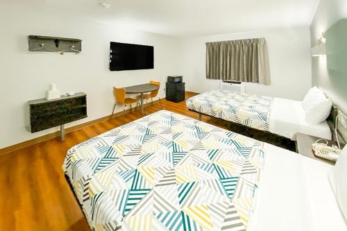 a room with two beds and a flat screen tv at The Reserve Inn in Salisbury