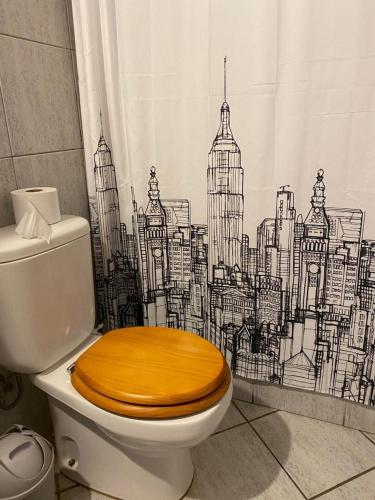 a bathroom with a toilet with a city shower curtain at Casa del Parque in Talca