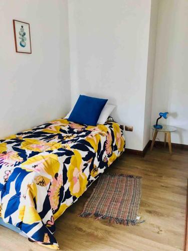 a bedroom with a bed with a blue and yellow blanket at Casa del Parque in Talca