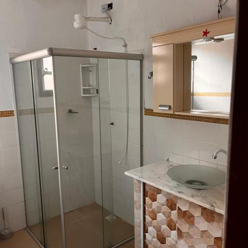 a bathroom with a glass shower and a sink at Casa in Baia Formosa-Bùzios in Búzios
