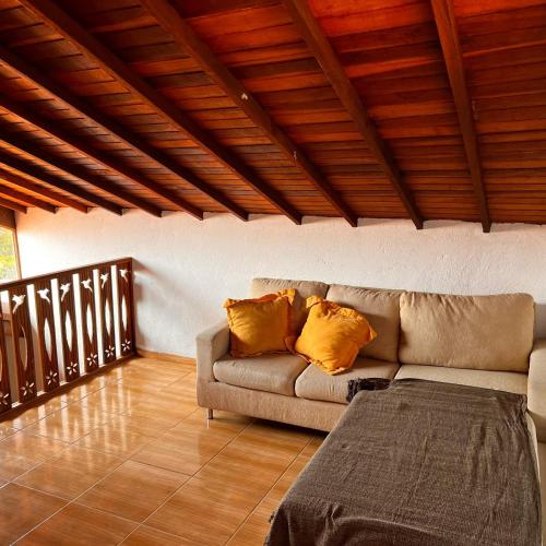 a living room with a couch and a wooden ceiling at Casa in Baia Formosa-Bùzios in Búzios