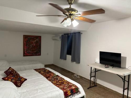 a bedroom with a ceiling fan and a bed and a desk at House in Monterrey Nuevo León in Monterrey