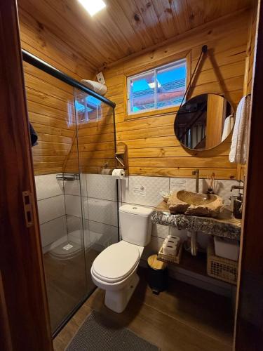a bathroom with a toilet and a sink and a mirror at Cabanas Paxixi - Mirante in Camisão