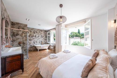 a bedroom with a bed and a tub and a sink at Villa Rosoliel in Cannes