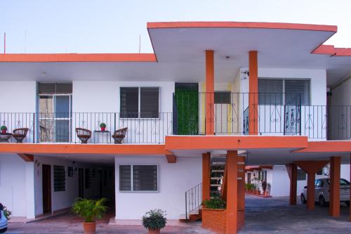 a building with a balcony with tables and chairs at Hotel Posada del Angel in Mérida