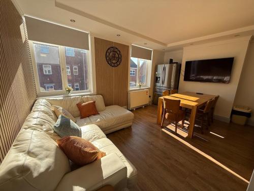 a living room with a white couch and a table at Spacious 4BR for Contractors, Groups, Families in Bournemouth