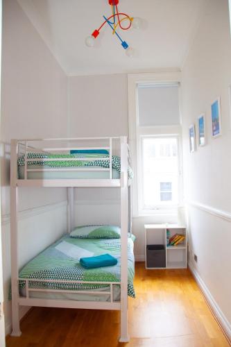 a bedroom with two bunk beds and a window at High Street 3BR city views near beach - Groups, Families, Contractors in Bournemouth