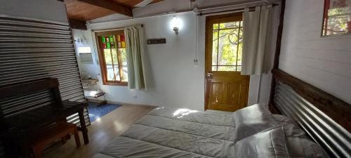 a room with a bed and a door and windows at Na Petko suite in Gaiman