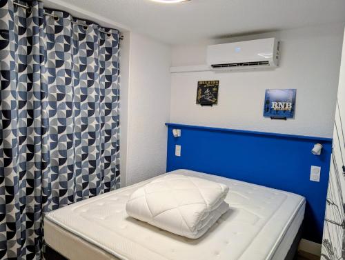 a small room with a bed with a blue headboard at Studio Music Blue - Bourgoin Centre in Bourgoin