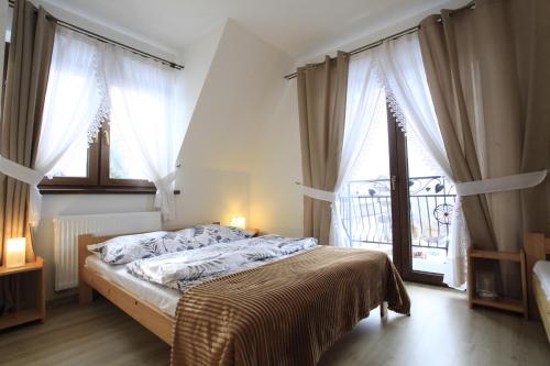 a bedroom with a bed and a large window at Pokoje gościnne u Sołtysów in Jurgów