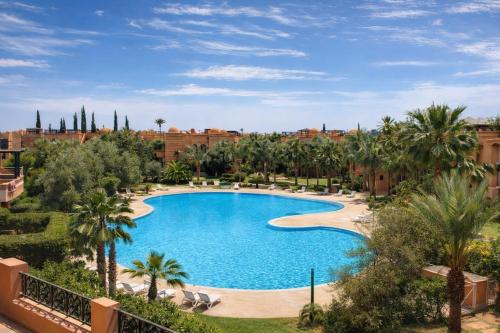 an overhead view of a pool with palm trees and buildings at Golden Palms Marrakech in Marrakesh