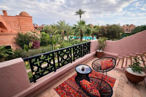 a balcony with a table and chairs on a patio at Golden Palms Marrakech in Marrakesh