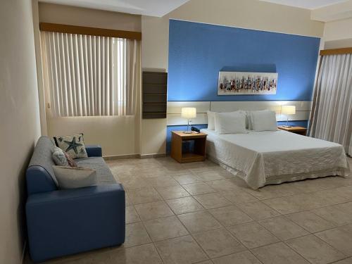 a bedroom with a bed and a blue wall at Pousada Barlavento in Iriri