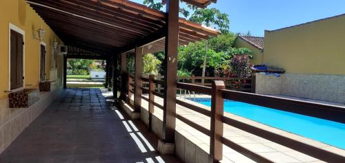 a house with a swimming pool and a fence at Casa em Praia Seca - Ideal para familia- Piscina- Churrasco- Em Condominio in Araruama