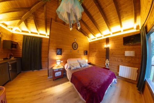 a bedroom with a bed in a wooden room at Pensión Cabañas Bosque Máxico de Bonxe in Outeiro de Rei