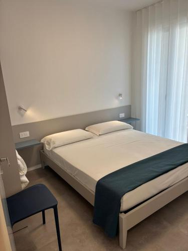 a bedroom with a bed and a chair in a room at Matilde Apartments Caorle in Caorle