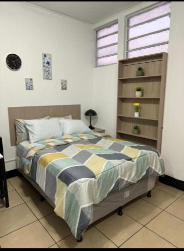 a bedroom with a bed and a book shelf at AeroloftGT in Estación Pamplona