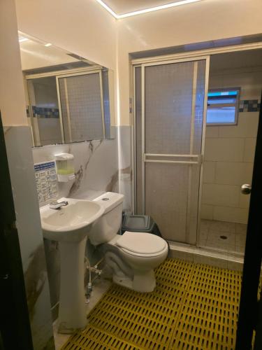 a bathroom with a toilet and a sink and a shower at Hostal Gastro Bar Casa Colibrí in Bogotá