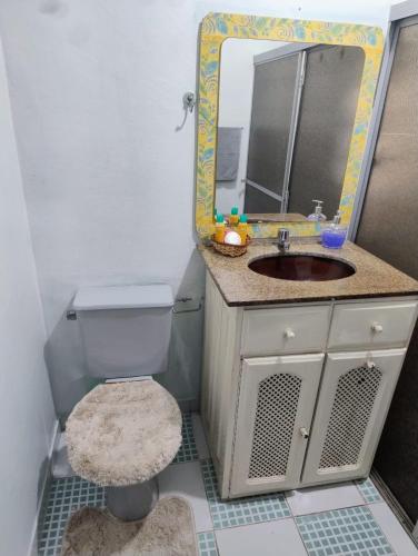 a bathroom with a sink and a toilet and a mirror at Edícula Planalto in Manaus