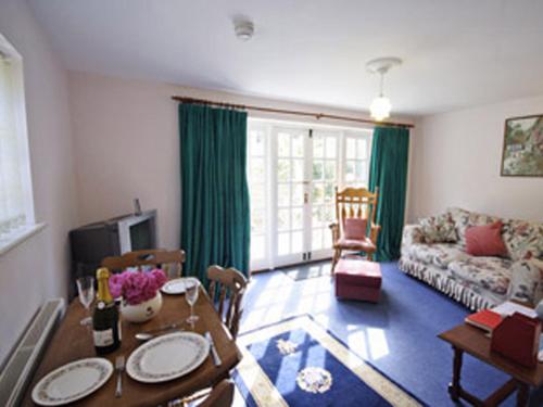a living room with a table and a couch at Wisteria Cottage in Aylsham