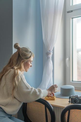 a woman sitting at a desk with a camera at Cloud Comfort Studio Willa Miejska Górka in Miejska Górka