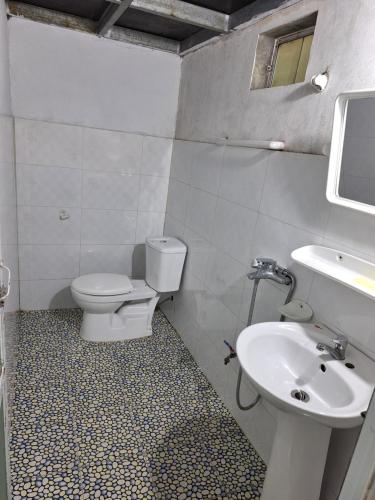 a white bathroom with a toilet and a sink at Beautiful Homestay Sapa in Sapa