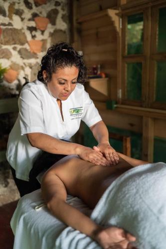 a woman in a spa treating a persons leg at Reserva Ecologica Nanciyaga in Catemaco