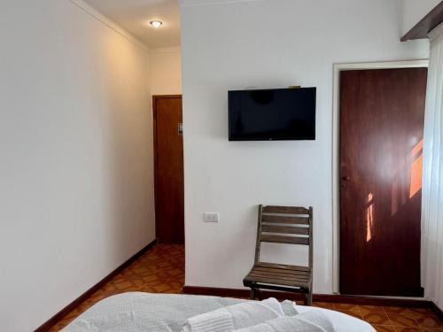 a bedroom with a bed and a television on a wall at Hotel Hijos Del Mar - Rincón Costero in Miramar