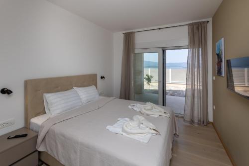 a bedroom with a white bed with a window at Villa Sole in Komarna