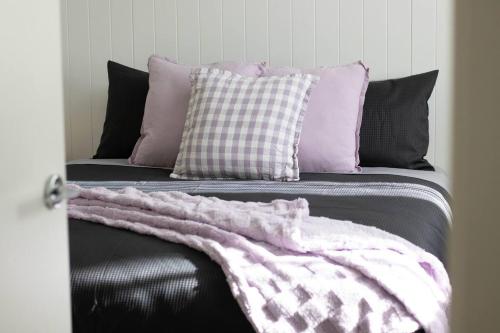 a black leather couch with pillows and a blanket at Lakes Edge 1 - 2BR Close to Lake in Wendouree